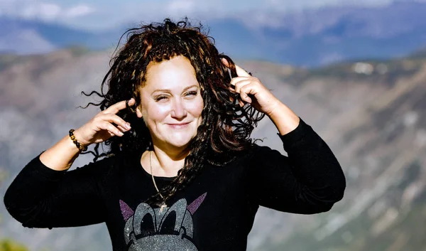 Donchuan dağları, Çin arka plan karşı uzun kıvırcık saçlı güzel gülümseyen kadın. Kavramı, seyahat bir kişi mutlu eder.