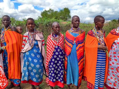 AFRICA, KENYA, MASAI MARA, MARCH, 2016 - Masai kadınları köyü Masai Mara, Kenya, Afrika 'da çok renkli pamuk elbiseler ve boncuklu mücevherler içinde
