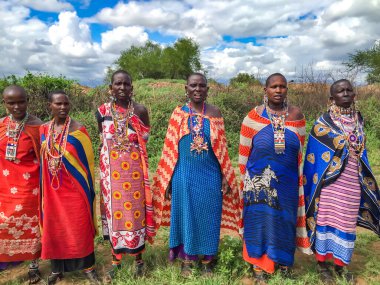 AFRICA, KENYA, MASAI MARA, MARCH, 2016 - Masai kadınları köyü Masai Mara, Kenya, Afrika 'da çok renkli pamuk elbiseler ve boncuklu mücevherler içinde