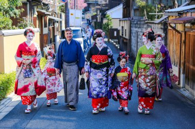 JAPAN, KYOTO, APRIL, 05, 2017 - Maiko kimonolu güzel kadın ve iki küçük kız ve Gion bölgesinde samuray kostümü giyen erkekler, Kyoto Japonya.