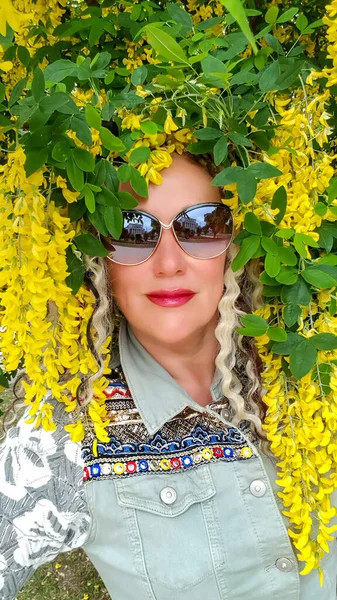 在拉脱维亚里加盛开的黄色相思树的枝条中 戴着太阳镜的漂亮女人 — 图库照片