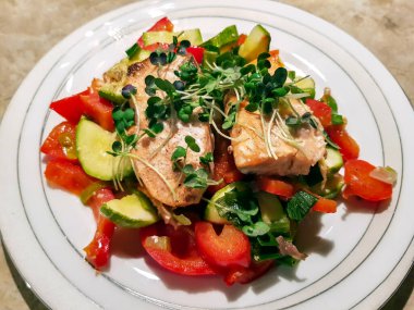 Mevsimlik yahnili sıcak salata, somon balığı ve taze otlar.