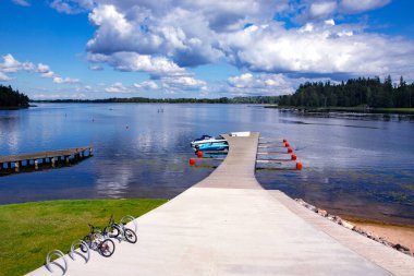LATVIA, ALUKSNE, AĞUSTOS, 2020 - Aluksne 'deki güzel büyük bir gölde motorlu tekneler için ahşap iskele