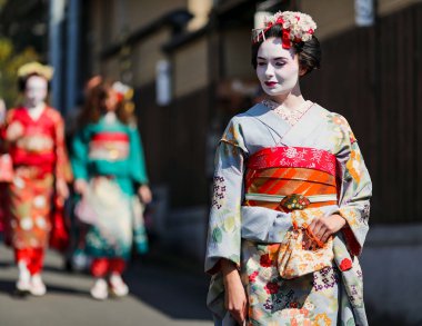 JAPAN, KYOTO, APRIL, 05, 2017 - Kyoto Japonya 'da yeşil bir çitin arka planına karşı eski moda Gion kasabasında Maiko kimonolu güzel bir kadının portresi.