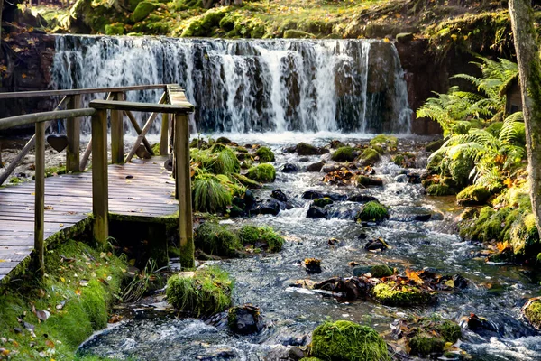 Kleiner Wasserfall Mit Einem Felsigen Fluss Und Einer Kleinen Holzbrücke — Stockfoto