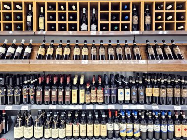 LATVIA, RIGA, EPTEMBER, 22, 2025: modern şarap butiği mağazasının içi. Alışveriş merkezi Riga, Letonya 'da çeşitli şaraplı ahşap raflar.