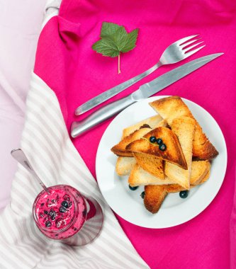 Ev yapımı frenk üzümü reçeli çatal ve bıçak üzerinde parlak koyu kırmızı masa örtüsü ile lezzetli tost ekmeği