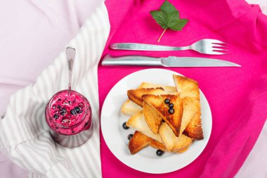 Ev yapımı frenk üzümü reçeli çatal ve bıçak üzerinde parlak koyu kırmızı masa örtüsü ile lezzetli tost ekmeği