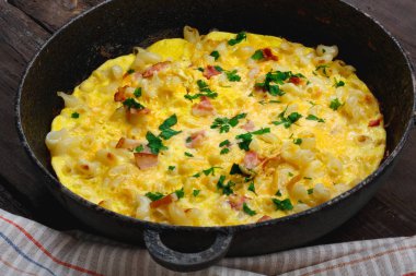 Pastırma, makarna ve yeşillik üzerinde eski siyah kızartma tavası ile geleneksel rustik omlet