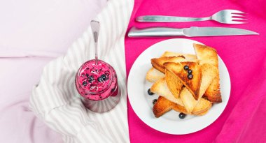 Ev yapımı frenk üzümü reçeli çatal ve bıçak üzerinde parlak koyu kırmızı masa örtüsü ile lezzetli tost ekmeği