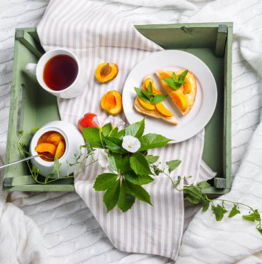 Ev yapımı Kayısı reçeli ve tepsi, zemin convolvulus çiçeklerin üzerine çay lezzetli Tost ekmeğine