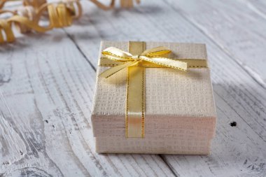 Eski vintage ahşap masa üzerinde bir yay ile altın hediye kutuları