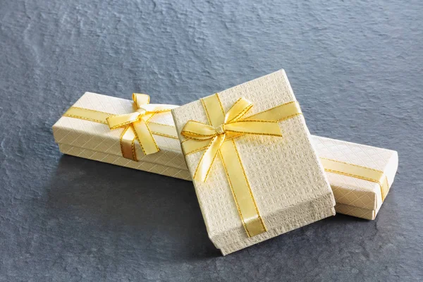 Golden gift boxes with a bow on old vintage  stone table