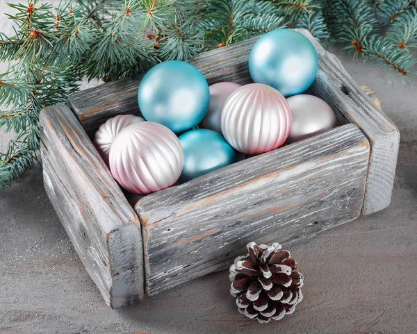 背景の緑のモミの枝で美しいピンクとブルー クリスマス ボールと古いヴィンテージ木箱 — ストック写真