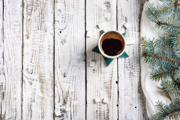 Cup of hot coffee with sugar and cinnamon on old wooden table with spruce branches. Top view flat lay group objects
