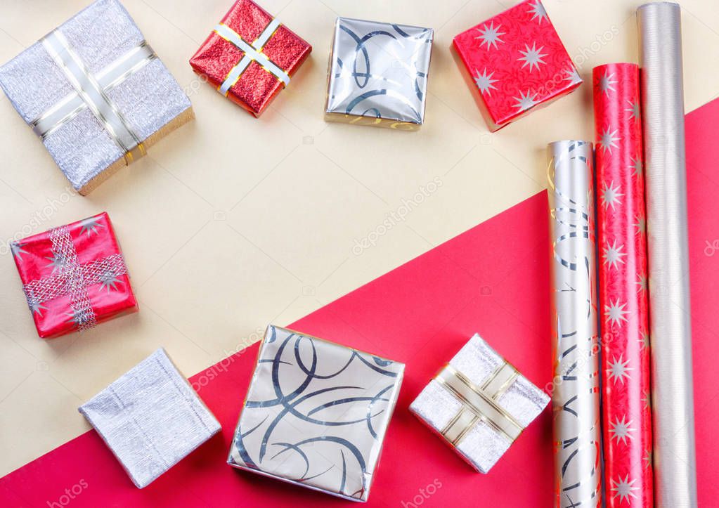 Golden gift boxes and red wrapping paper on bright background.Top view flat lay group objects