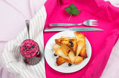 Ev yapımı frenk üzümü reçeli çatal ve bıçak üzerinde parlak koyu kırmızı masa örtüsü ile lezzetli tost ekmeği