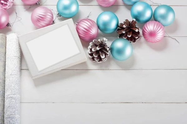 粉红色和蓝色圣诞球与礼品盒和包装纸在老木桌上 — 图库照片
