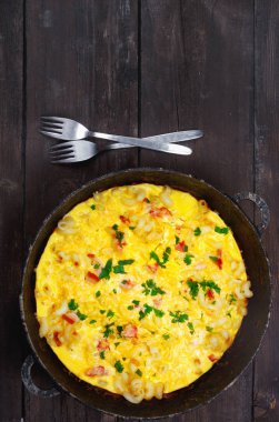 Pastırma, makarna ve yeşillik üzerinde eski siyah kızartma tavası ile geleneksel rustik omlet