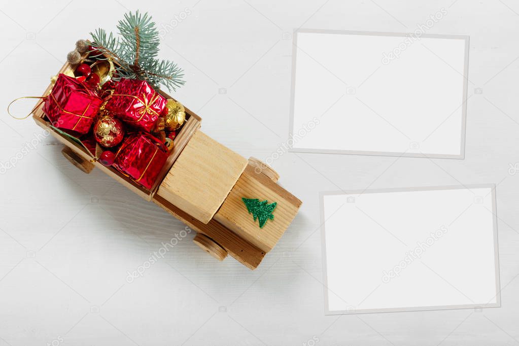 Old vintage toy wooden car with gifts and Christmas balls, paper frame on white background, Top View Flat Lay Group Objects
