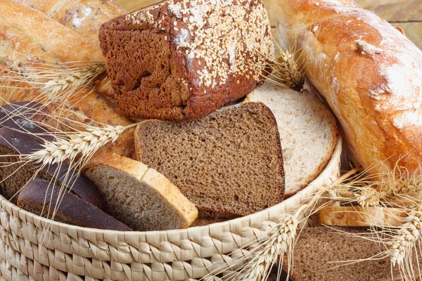 Bread from rye and wheat flour of rough grinding in wicker basket on wooden table