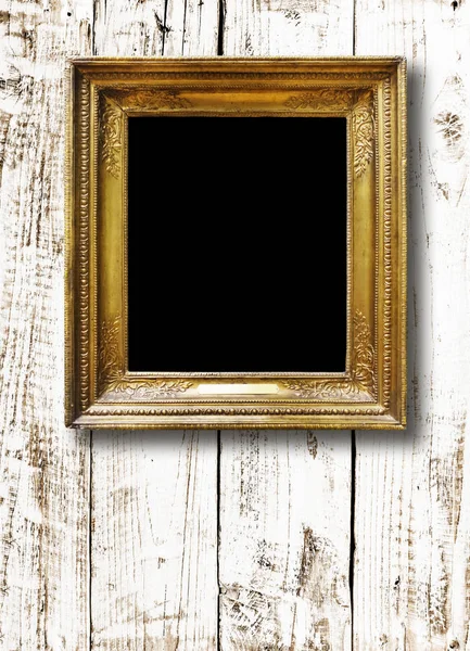 Old vintage gold ornate frame for picture on grunge wooden wall