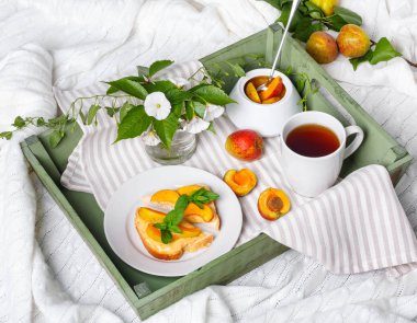 Ev yapımı Kayısı reçeli ve tepsi, zemin convolvulus çiçeklerin üzerine çay lezzetli Tost ekmeğine