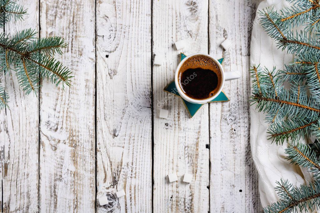 Cup of hot coffee with sugar and cinnamon on old wooden table with spruce branches. Top view flat lay group objects