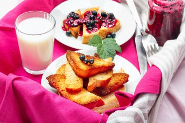 Lezzetli tost ekmeği ev yapımı frenk üzümü reçeli ve süt parlak kırmızı masa aralığında.