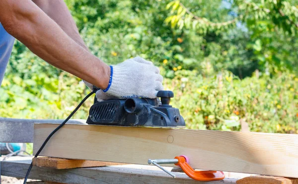 Ξυλουργός Συνεργάζεται Ηλεκτρική Μηχανή Πλανίσματος Για Ξύλινη Σανίδα Στην Εξωτερική — Φωτογραφία Αρχείου