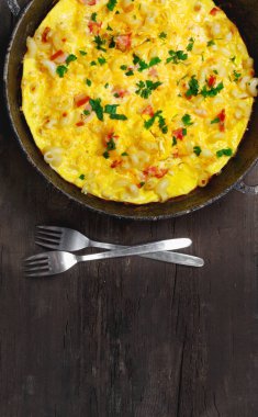 Pastırma, makarna ve yeşillik üzerinde eski siyah kızartma tavası ile geleneksel rustik omlet