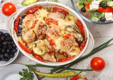 Traditional tasty rustic stew of chicken and vegetables, decorated with tomatoes, peppers and cheese.  With Greek salad and black olives clipart
