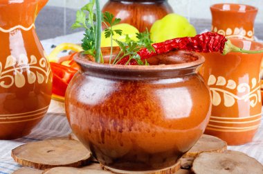 Çiğ sebze ve eski vintage ahşap masa kil tencere içinde baharatlar ile geleneksel rustik ev gulyas.