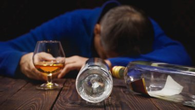 Bardak viski ve şişe masanın üzerinde gece uyku erkek alkolik. Alkol ve bağımlılık. CONCEP