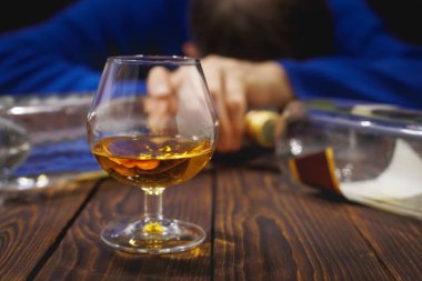 Bardak viski ve şişe masanın üzerinde gece uyku erkek alkolik. Alkol ve bağımlılık. CONCEP