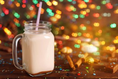 Sıcak kakao süt, tarçın, cam fincan şeker ve saman tüp Noel köknar ve koniler ile arka plan bulanıklık bokeh