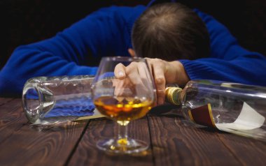 Bardak viski ve şişe masanın üzerinde gece uyku erkek alkolik. Alkol ve bağımlılık. CONCEP