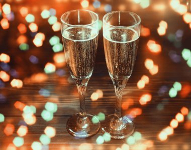 İki bardak şampanya yılbaşı ile parlak glitter, ışıklar, ahşap tablo bokeh bulanıklık