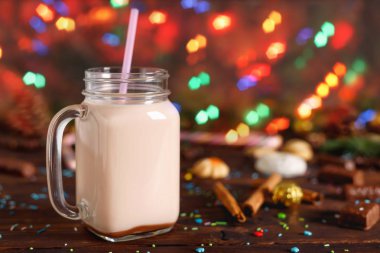 Sıcak kakao süt, tarçın, cam fincan şeker ve saman tüp Noel köknar ve koniler ile arka plan bulanıklık bokeh