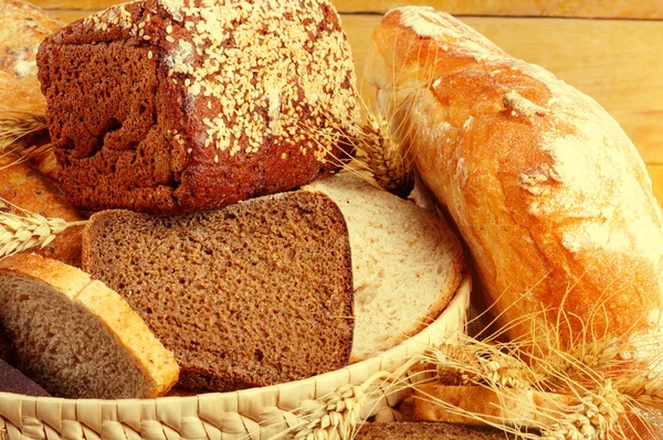 Bread from rye and wheat flour of rough grinding in wicker basket on wooden table