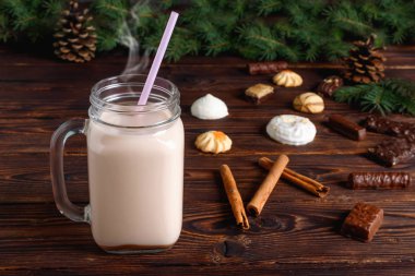 Sütlü, tarçınlı, şekerli ve saman tüplü bir bardak sıcak kakao.