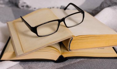 Masada gözlüklü açık vintage kitap yığını