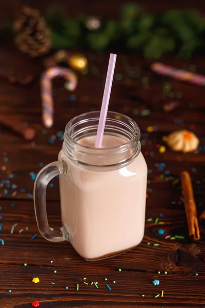 クリスマスのモミやコーンを背景にミルク シナモン キャンディーやストローチューブとホットココアのガラスカップ — ストック写真