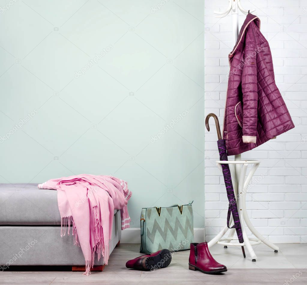 Stylish hallway interior with with clothes and shoes in pink color