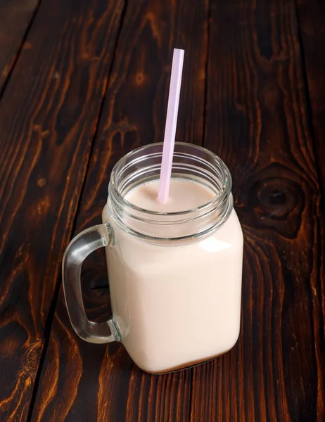 熱いココア ミルクと素朴な木製のテーブルにストローの管のガラスのコップ — ストック写真