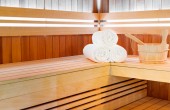 Tradiční klasická dřevěná sauna pro odpočinek se lžící vody a ručníky