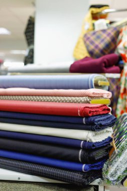 Various multicolored textiles for sale in  shop clipart