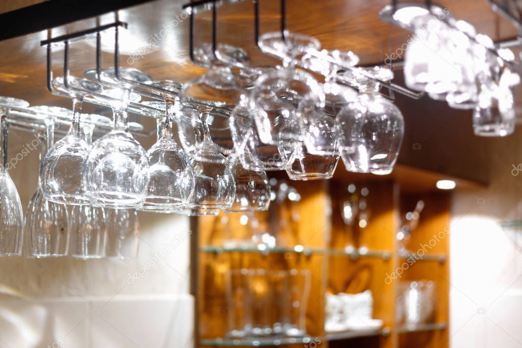 Empty  glasses hanging above the bar in the restaurant. 