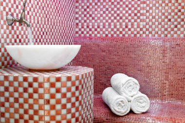 Taş duvarlar, lavabo ve temiz havlu yığını ile geleneksel Türk Hamamı