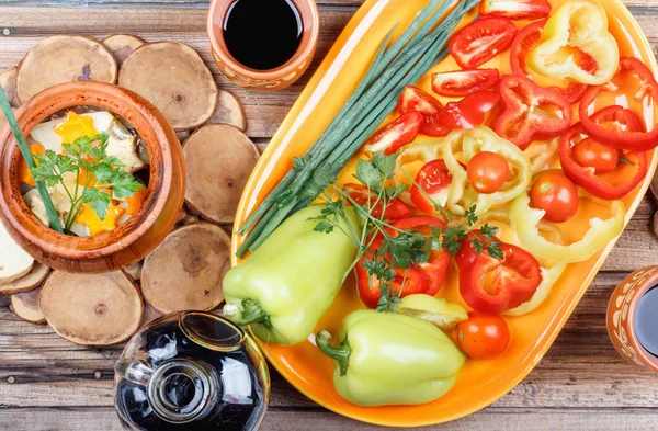 Traditioneller rustikaler Gemüseeintopf mit rohem Gemüse, Gewürze in Tontöpfen mit Rotwein auf altem Holztisch. — Stockfoto